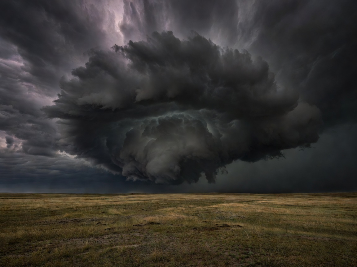 Massive dark storm cloud swirling over flat plains landscape